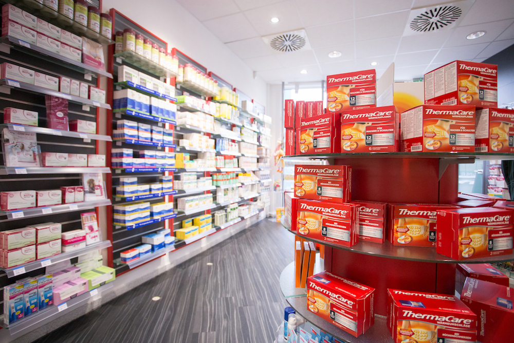 Aufsteller in der Apotheke mit roten Produkten von ThermaCare Wärme